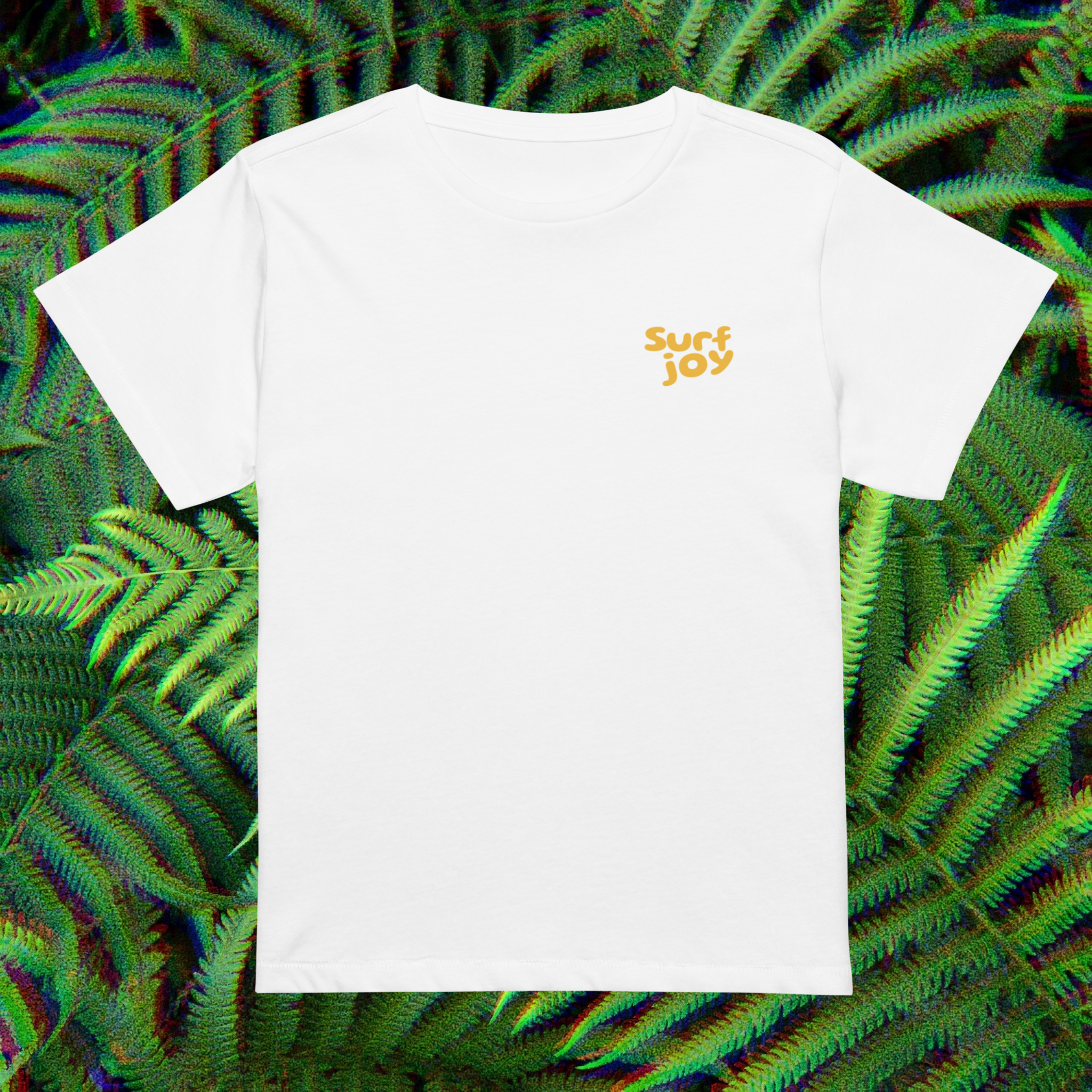 White t-shirt with 'Surf Joy' text on a green leafy background