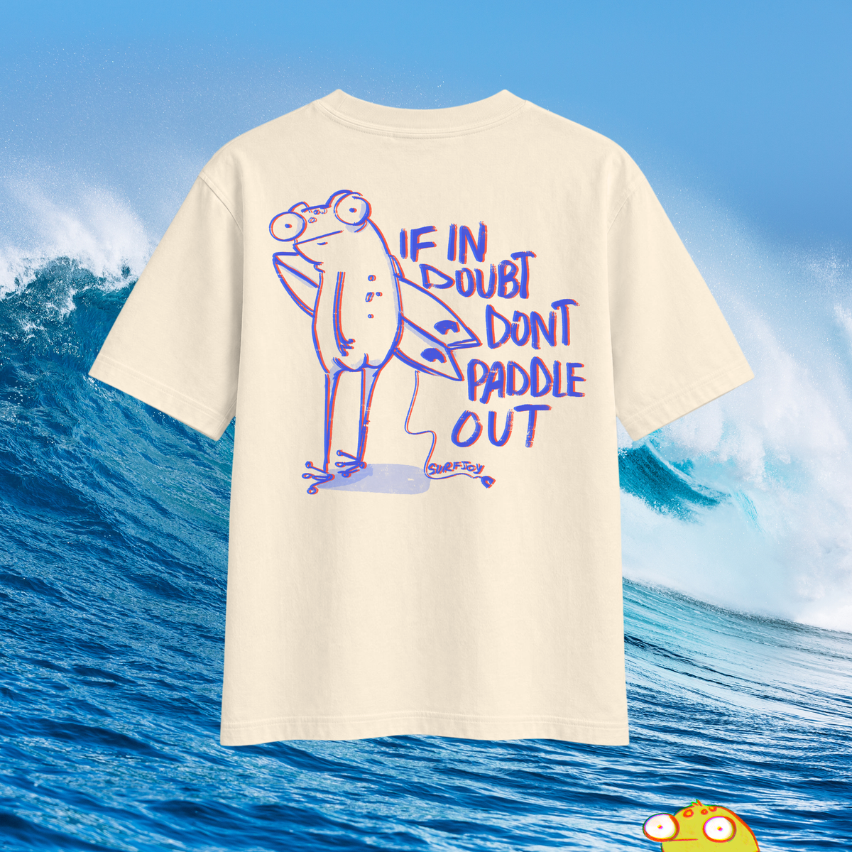 Oversized T-shirt with humorous graphic of frog character with surfboard and quote "If in doubt don't paddle out" printed in the back shown over an ocean wave background