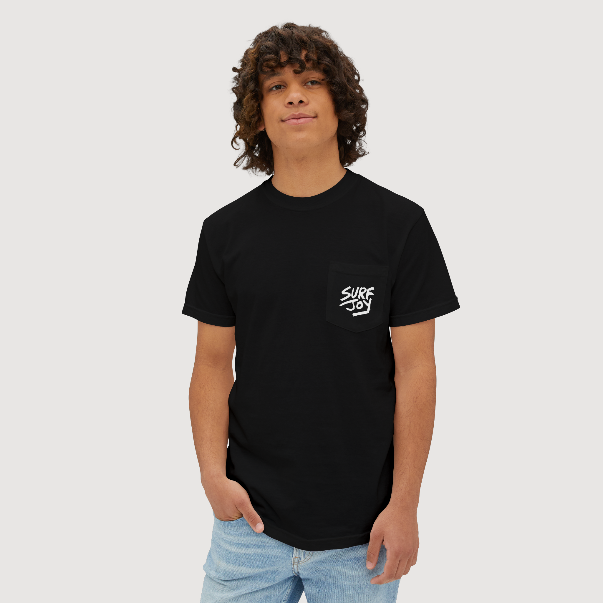 hawaiian surfer model wearing a black surfjoy t-shirt featuring a design of a frog catching an air on a wave with a speech bubble that says 'rippit'