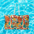 front view of an oversized beach bag with a groovy all over print of cute fish characters on the beach