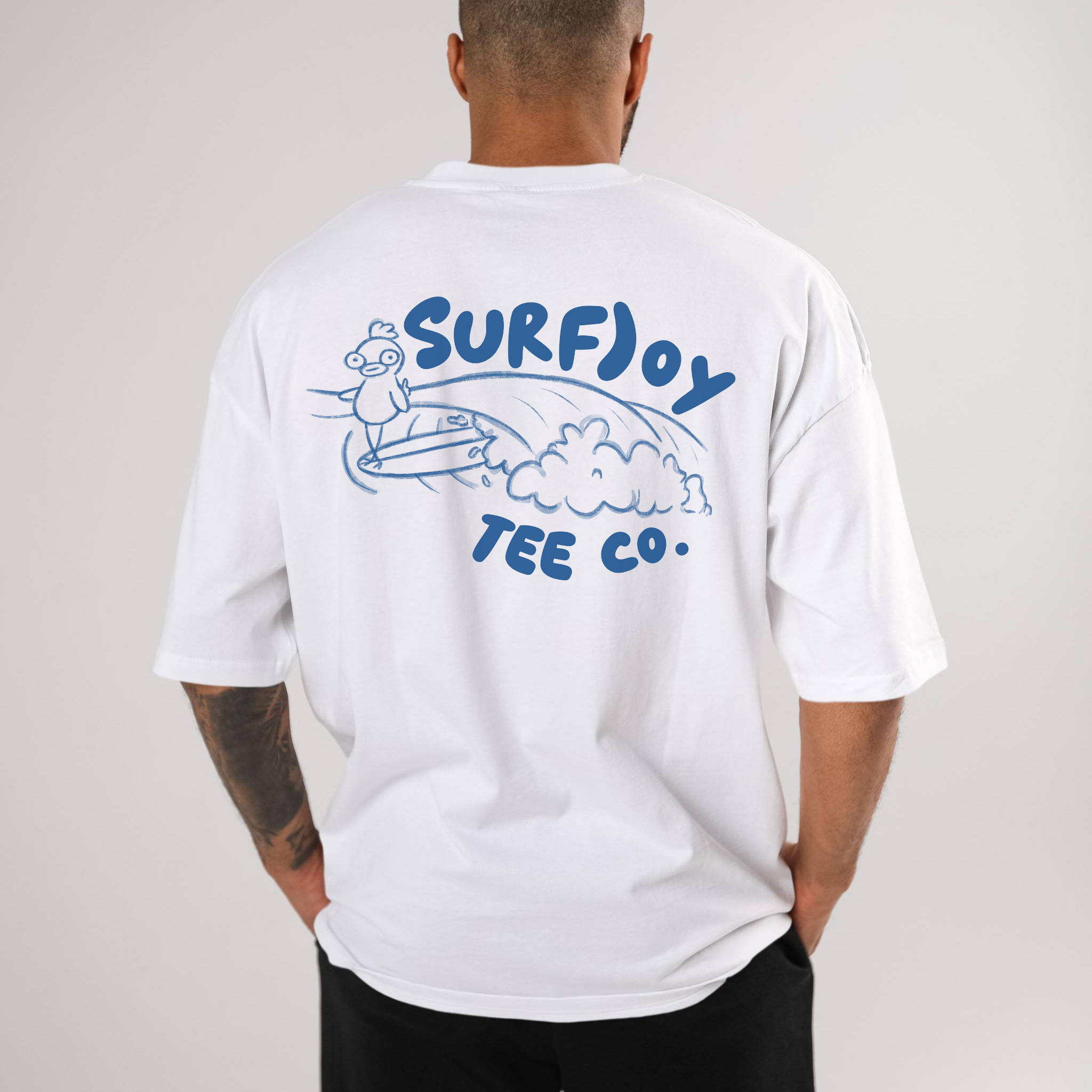 man wearing a surfjoy t-shirt with funny design of a surfing chicken by text that says 'surfjoy tee co.'
