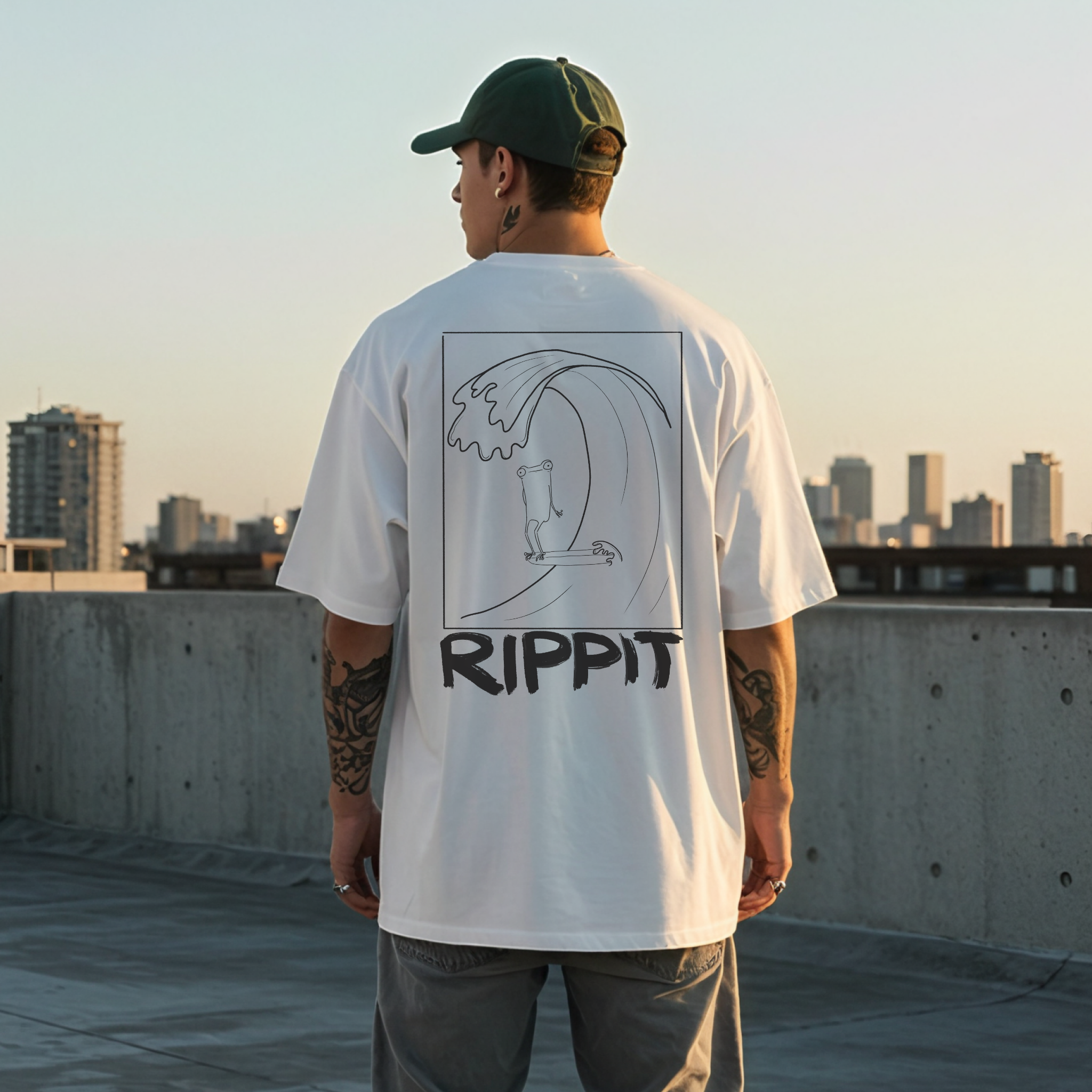 back view of a male model wearing a white surfjoy t-shirt with a design of a surfing frog and text that says 'rippit'