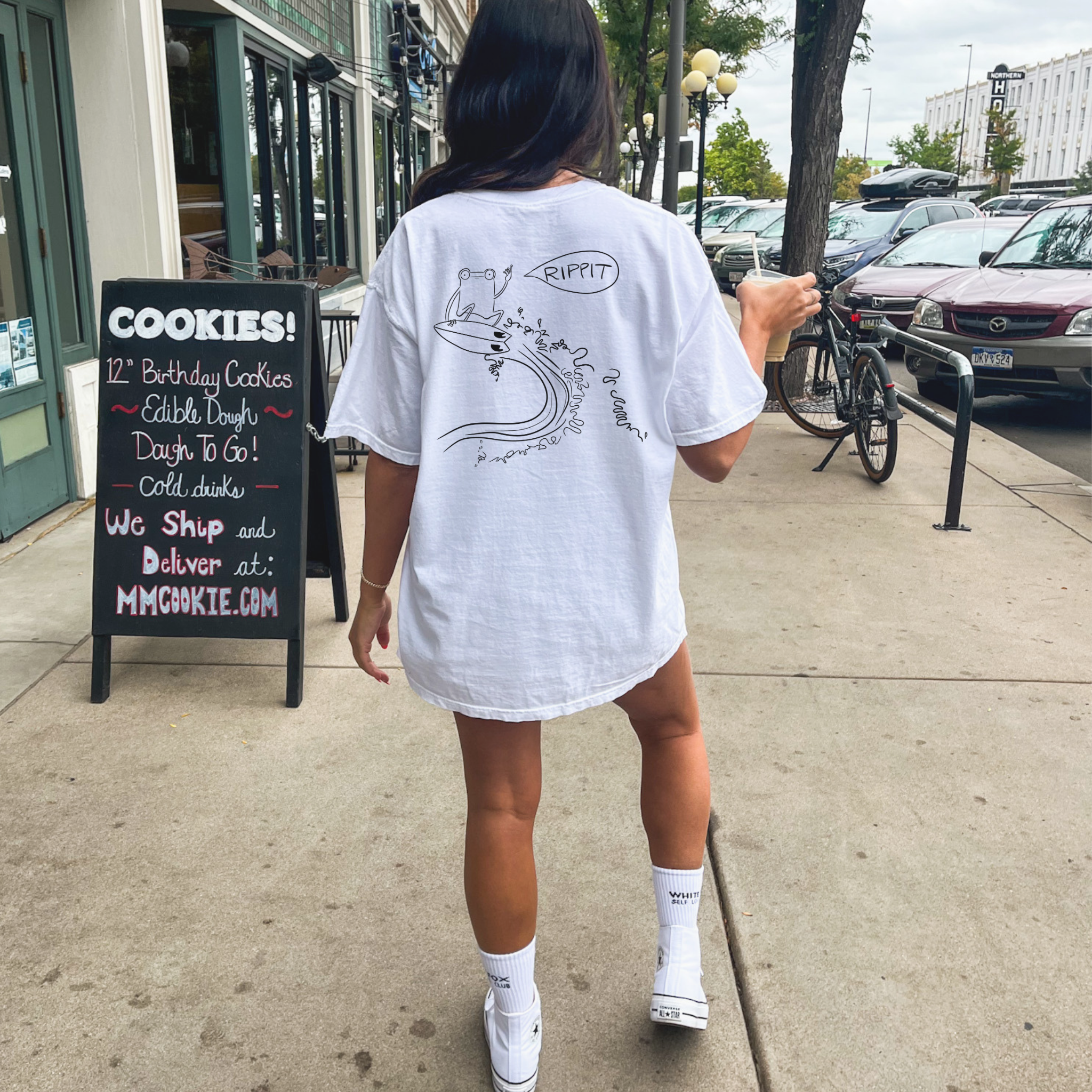 female model wearing the surfjoy original rippit t-shirt with a design of a frog catching air on a wave