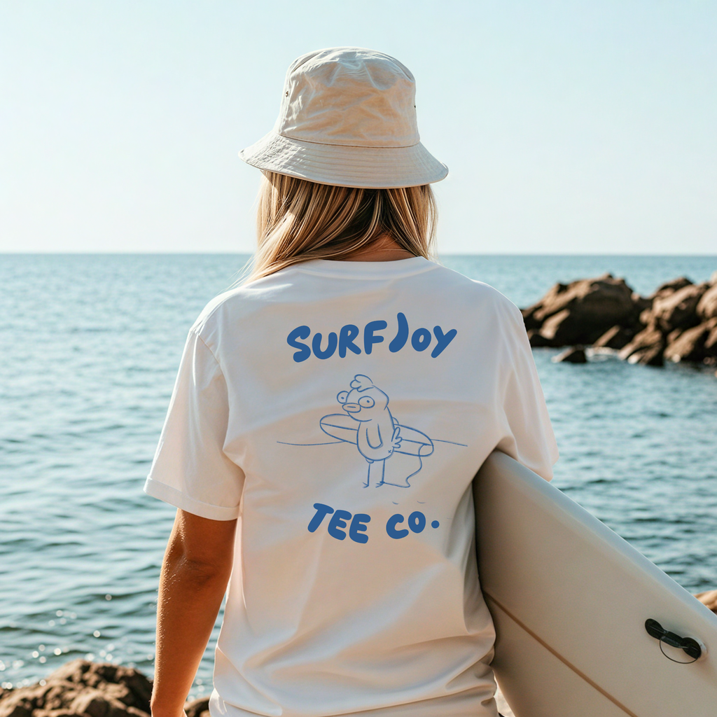 female surfer wearing a funny surf shirt standing by the ocean