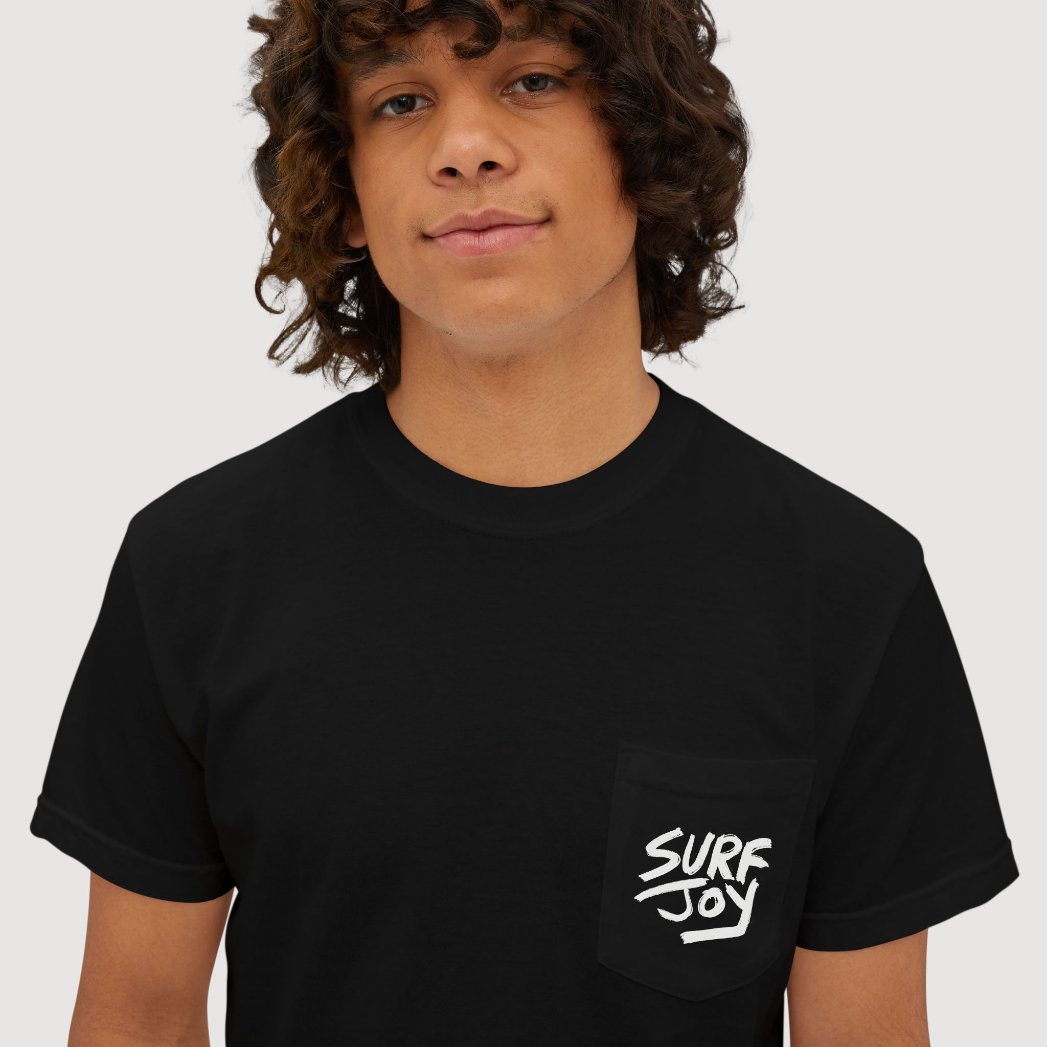 zoom in view of surfjoy tshirt featuring the surfjoy logo on the front pocket of a black t-shirt